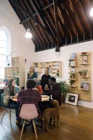 Interior del espacio de eventos con vigas de madera y personas reunidas