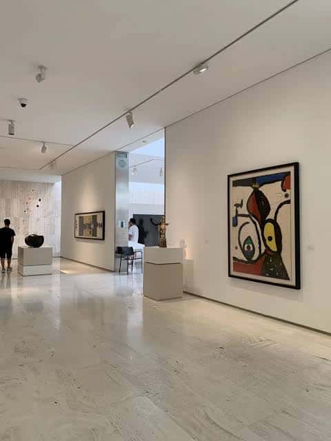 Galería de arte contemporáneo con obras enmarcadas y suelo de mármol