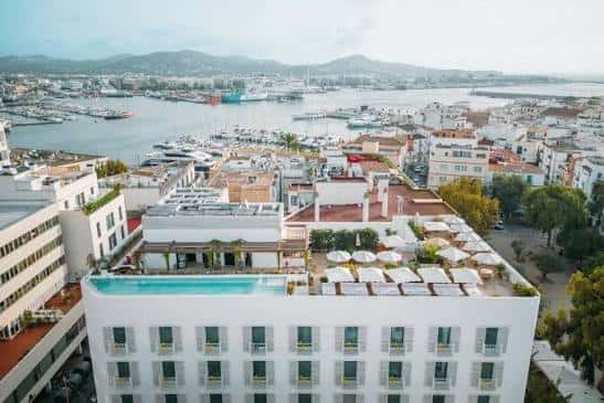 Vista aérea del hotel The Standard Ibiza con piscina en la azotea y puerto al fondo