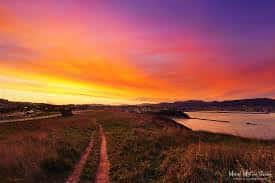 Amanecer sobre las campas de Aixerrota con sendero costero y cielo colorido