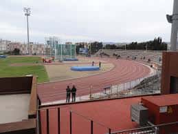 Vista del estadio desde las gradas con pista de atletismo y césped central