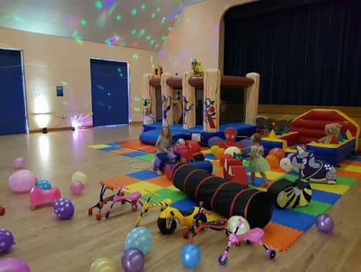 Interior del Woolwell Centre decorado para una fiesta infantil con globos y juguetes