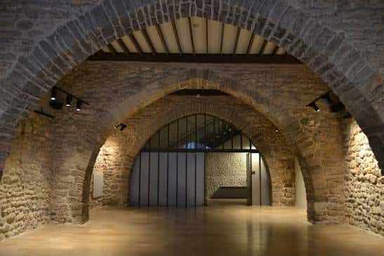 Interior de la sala de eventos con bóvedas de piedra y suelo pulido
