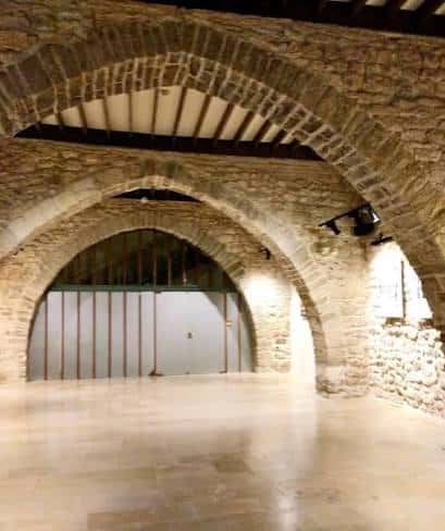 Vista del espacio interior con arcos de piedra y iluminación moderna