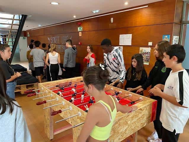 Interior del centro mostrando actividad recreativa con mesa de fútbol sala