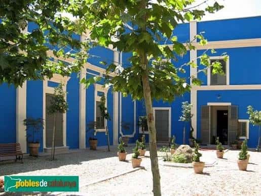 Fachada exterior de Casa Canals con árboles y patio soleado