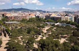 Panorámica del parque urbano con zonas verdes y edificios históricos
