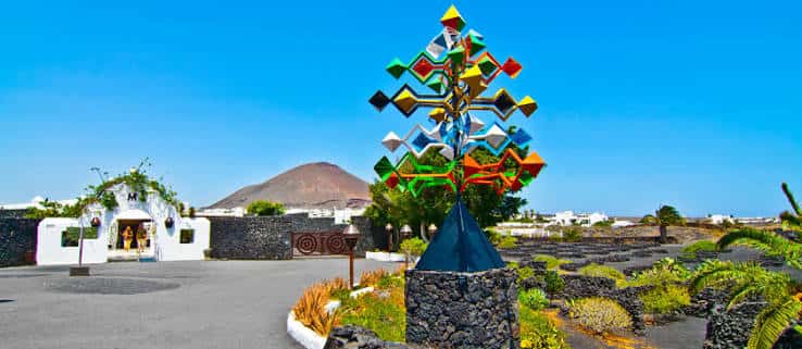 Escultura colorida y paisaje volcánico en el Parque Marítimo César Manrique