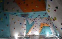 Interior del rocódrom con paredes de escalada y colores vivos