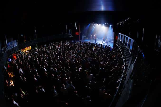 Concierto en el teatro Paral·lel 62 con público y escenario iluminado