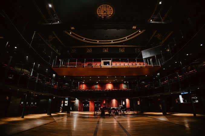 Interior del teatro Paral·lel 62 con escenario y butacas vacías en penumbra