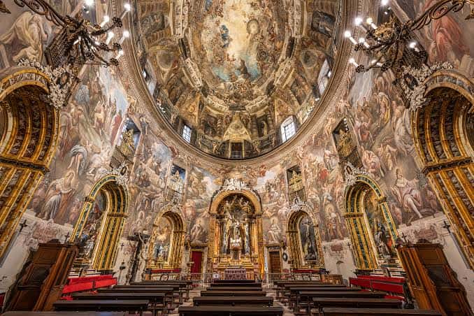 Interior de la iglesia mostrando la cúpula decorada y el altar central