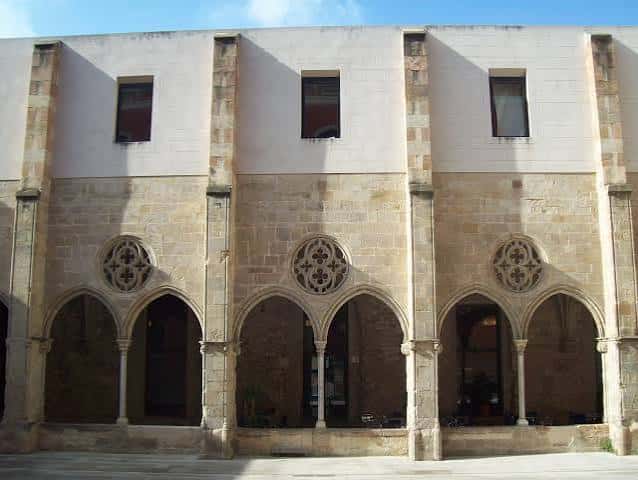 Vista frontal del edificio con arquería gótica y detalles arquitectónicos en piedra