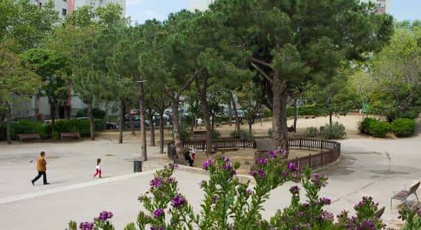 Área de paseo con árboles y personas caminando en el parque