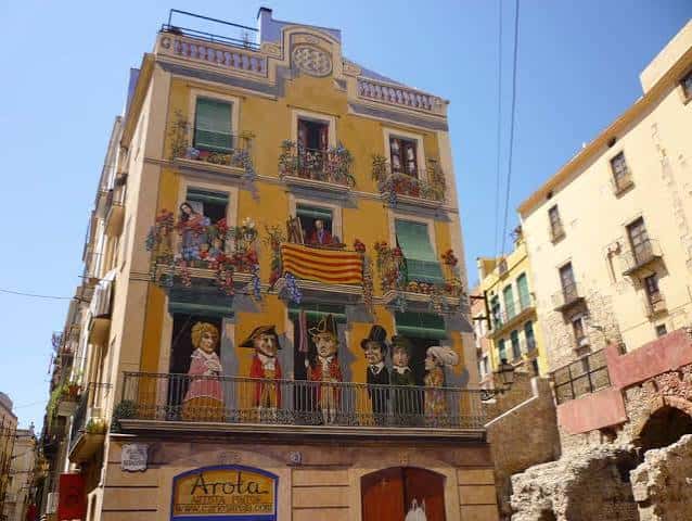 Fachada de la Plaça dels Sedassos con murales artísticos y detalles arquitectónicos