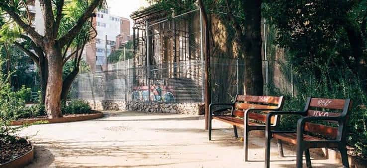 Zona de descanso con bancos de madera y árboles en el jardín