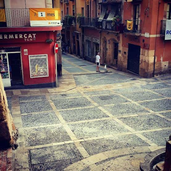 Vista de la Plaça de les Cols con su característico empedrado y edificios históricos