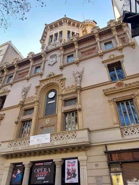 Fachada principal del Teatre Poliorama con detalles arquitectónicos y reloje central