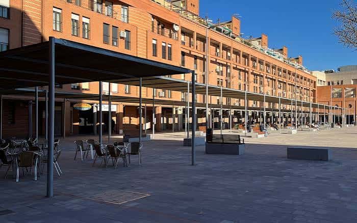 Área de la plaza con pérgolas y mobiliario urbano, ideal para eventos al aire libre