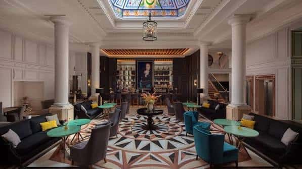 Lobby principal del hotel con techo de vitral y decoración elegante
