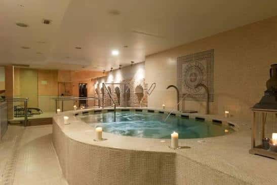 Piscina interior con jacuzzi y ambiente relajante con velas