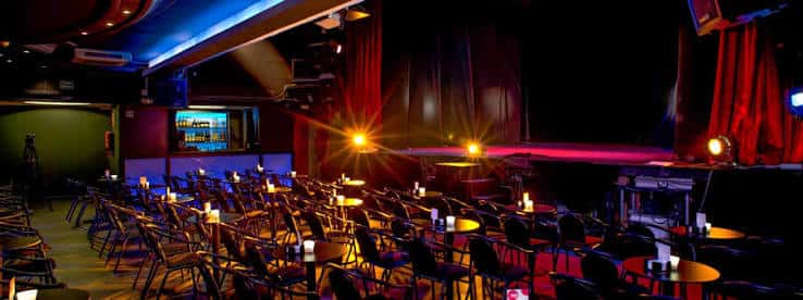Interior del teatro con mesas y butacas dispuestas para evento