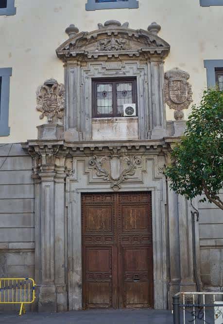 Detalle de la entrada principal con escudo y puerta de madera