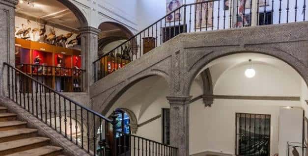 Escalera interior con barandilla de hierro y arcos