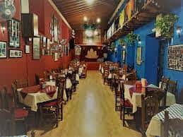 Vista longitudinal del salón de la peña con decoración tradicional y ambiente acogedor