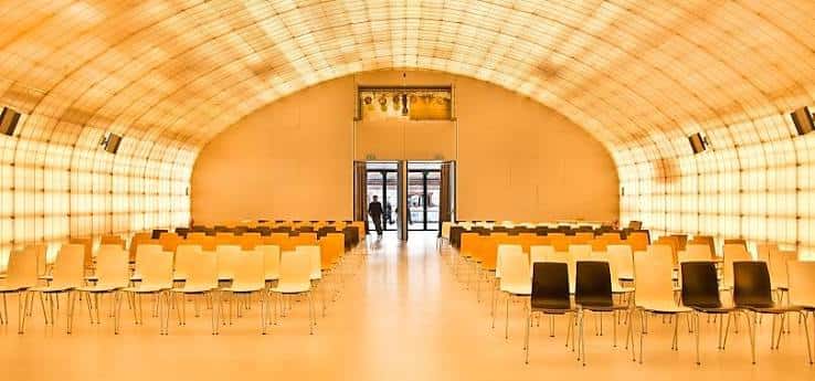 Sala de eventos con techo abovedado y sillas dispuestas para conferencias o presentaciones