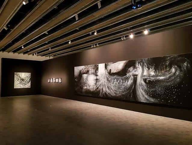 Interior de una sala de exposiciones con arte abstracto en las paredes