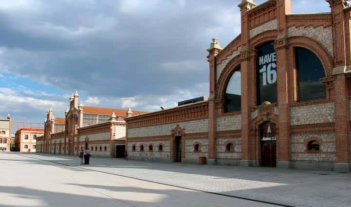 Fachada principal del Matadero Madrid con letrero 'NAVE 16' y arquitectura industrial restaurada