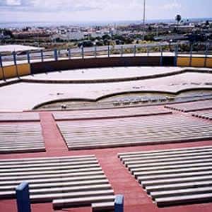 Interior del auditorio con gradas de hormigón y vista panorámica de la ciudad desde las alturas
