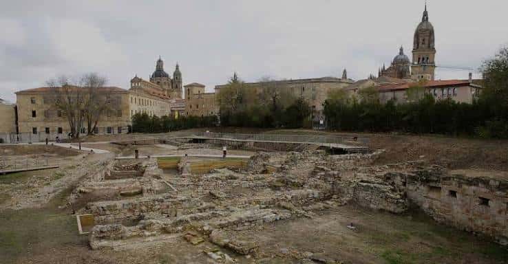Vista general de las excavaciones romanas con edificios históricos al fondo