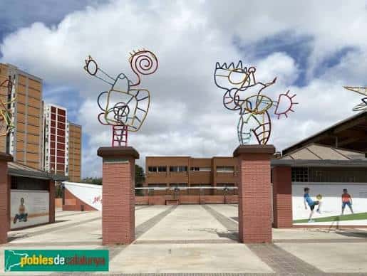 Detalle de las esculturas metálicas coloridas en la entrada de la plaza