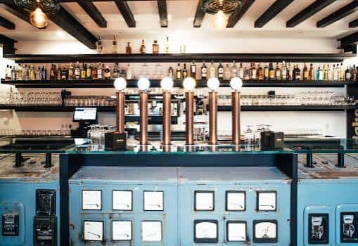 Bar con estanterías de botellas y grifos de cerveza