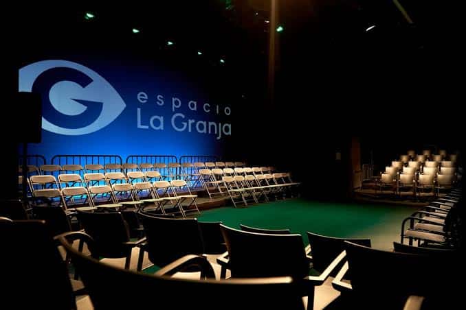 Sala de exposiciones con obras colgadas y vitrinas de exhibición