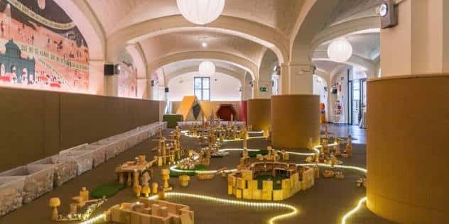 Área de juegos con estructuras de madera y luces decorativas