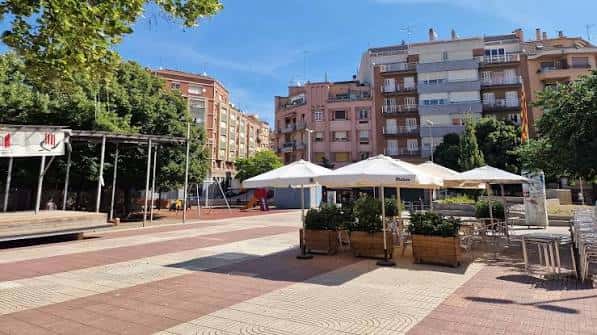 Vista panorámica de la Plaça Catalunya con terrazas y edificios residenciales al fondo