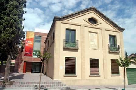 Fachada principal de la Casa Aymat con detalles arquitectónicos y balcones, bajo cielo azul