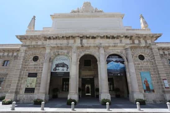 Entrada monumental del edificio con carteles de exposiciones