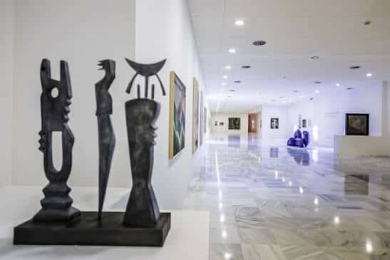 Galería de arte con esculturas modernas y suelo de mármol