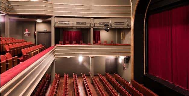 Ángulo lateral del auditorio mostrando los niveles de asientos y el telón rojo