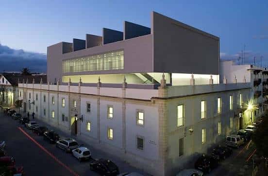 Vista exterior del Teatro Municipal Pedro Muñoz Seca al atardecer, mostrando la fachada histórica y la ampliación moderna