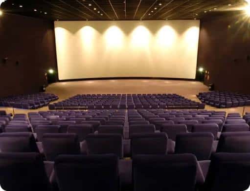 Interior de una sala de cine con butacas y pantalla grande