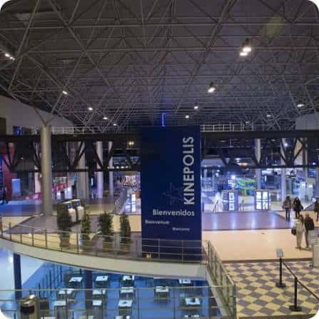 Hall principal de Kinépolis con estructura metálica y cartel de bienvenida