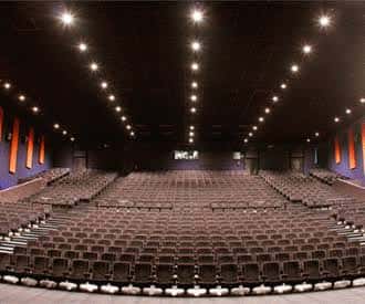Sala de cine amplia con butacas dispuestas en gradas y techo con iluminación