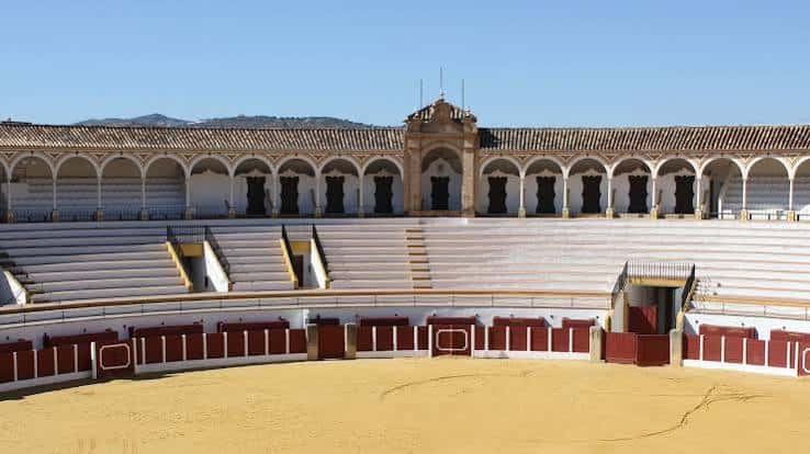 Interior de la plaza de toros con vista a las gradas y la arena desde el nivel del ruedo