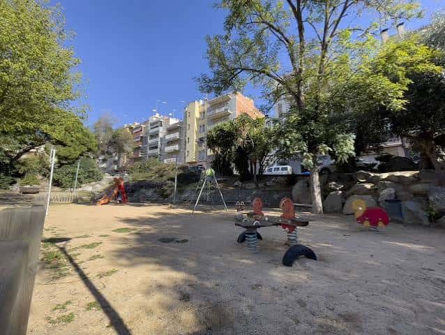 Zona de juegos infantiles con columpios y toboganes en el parque