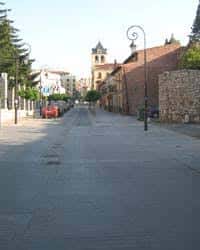 Calle peatonal en el Barrio Húmedo de León con edificios tradicionales y campanario al fondo
